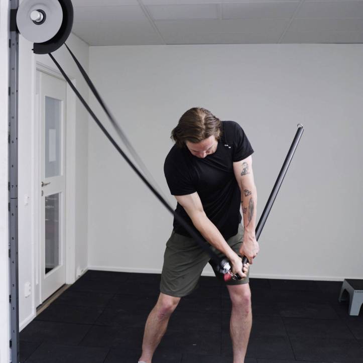 Mann trainiert im Fitnessstudio mit einem Widerstandsband.